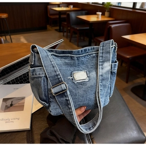 Détail du sac bandoulière en jean bleu avec poche latérale et large bandoulière réglable