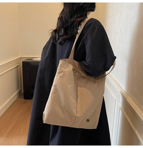 Texture détaillée d'un grand sac fourre-tout imperméable abricot avec logo minimaliste