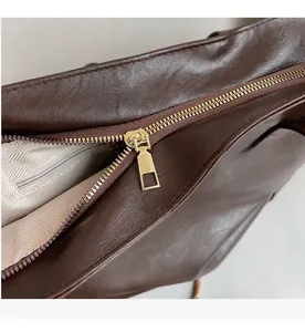 Close-up of smooth gold zipper and durable herringbone fabric lining in a tote bag