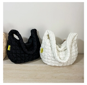 Détail de cabas matelassés en noir et blanc avec étiquette latérale tendance