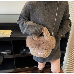 Détail d'un sac à main en peluche marron clair avec chaîne à billes argentée et texture