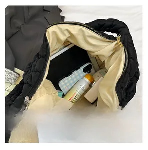 Vue macro d'un grand sac cabas matelassé noir montrant l'intérieur spacieux pour tablettes