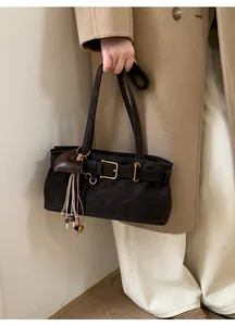Detail of dark brown matte shoulder bag with vintage buckle and heart charm