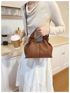 Sac à main marron en cuir grainé avec détails argentés dans un café chaleureux