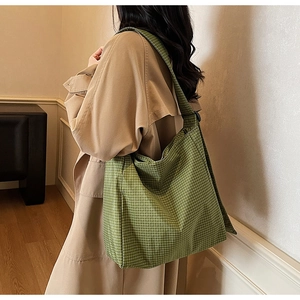 Detail of green plaid oxford tote bag showing durable fabric and wide shoulder strap