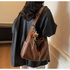 Detailed view of brown faux leather bucket bag featuring a cute bear plush charm