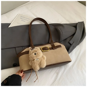 Detailansicht der Retro-Umhängetasche in Braun und Beige mit Plüschbären-Anhänger