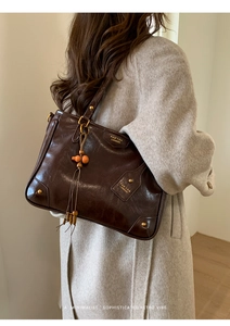 Brown vintage leather tote bag with wooden bead tassel and gold hardware detail