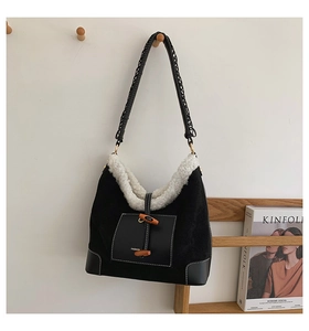 Detail of plush dumpling bag with black suede, white fleece trim, and wooden toggle button