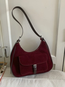 Burgundy suede hobo bag with dark brown strap and silver buckle pocket in chic half-moon shape