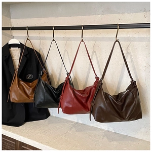 Row of large crescent tote bags in leather showing multiple vintage color variations