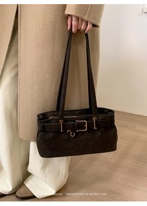 Detailed view of vintage matte leather baguette bag with elegant golden belt buckle detail
