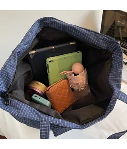 Top view showing large interior capacity of the blue checkered tote bag with daily items