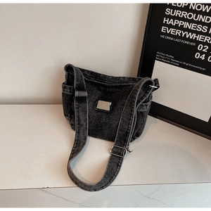 Détail du sac bandoulière en denim noir délavé avec plaque argentée et sangle