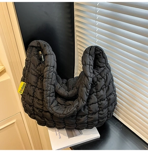 Détail du sac fourre-tout matelassé noir avec étiquette FASHION jaune vif sur le côté