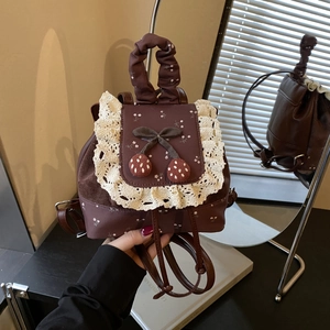 Détails du mini sac à dos marron vintage avec bordure en dentelle et décor cerise