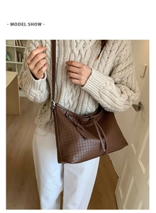 Détail de la texture tressée du sac cabas marron foncé avec bandoulière et pompon décoratif