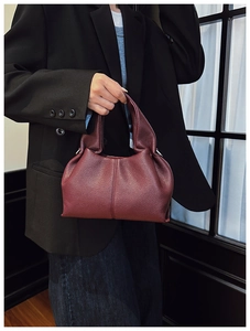 Détail du sac à main en cuir grainé bordeaux avec un design minimaliste épuré