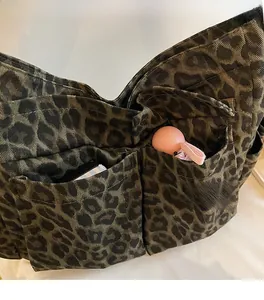 Close-up of leopard print canvas tote bag featuring two front pockets for storage