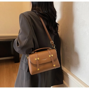 Close-up of caramel brown pebble leather crossbody bag with vintage gold hardware details