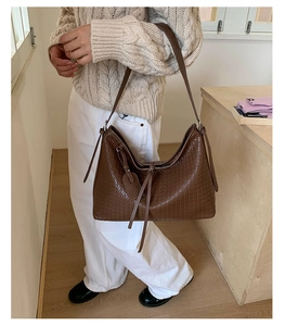 Détail d'un sac cabas marron à texture tressée montrant le design spacieux en similicuir