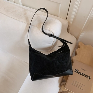 Detail of minimalist black hobo bag with suede texture and smooth leather base