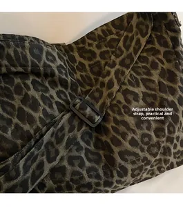 Close-up of adjustable black strap on leopard print canvas tote with twill fabric detail