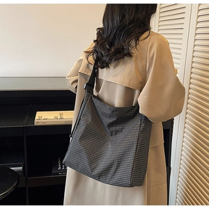 Detailed view of the checkered canvas tote bag with adjustable black wide shoulder strap