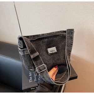 Détail du sac à bandoulière en denim gris délavé montrant la texture vintage et métal