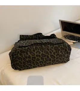 Detailed view of leopard print canvas bag with multiple flap pockets and sturdy fabric
