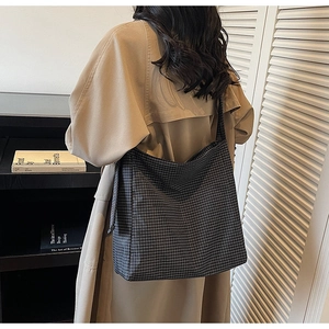 Close-up of the black and white checkered pattern on a large canvas tote bag