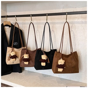 Détail de sacs hobo en daim avec accents floraux et breloques ours en peluche divers coloris
