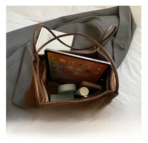 Large capacity dark brown suede tote bag showing spacious interior with iPad and books