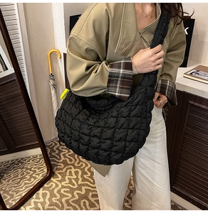 Sac croissant matelassé noir avec étiquette Fashion porté à l'épaule pour femme