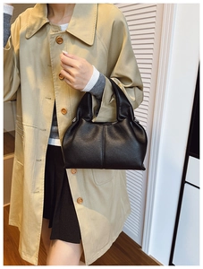 Détails d'un sac à main élégant en cuir grainé noir avec des plis souples et des surpiqûres