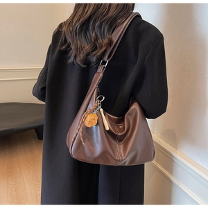 Detail of large brown hobo bag featuring white contrast stitching and soft PU leather texture