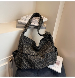 Detail shot of leopard print canvas bag with large front flap pockets and wide strap