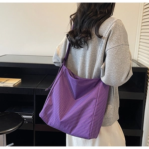 Detail of a purple plaid oxford tote bag showing large capacity and crossbody strap