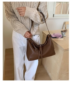 Gros plan d'un sac hobo marron foncé avec texture tressée et bandoulière