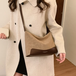 Fashionable khaki suede and dark brown leather crossbody bag styled with a cream wool coat