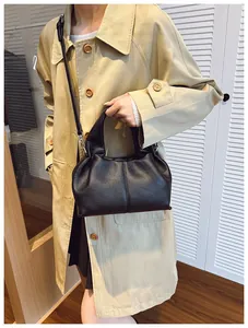 Détail du cuir grainé noir du sac seau chic avec des finitions métalliques argentées