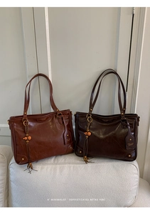 Detailed close-up of retro leather tote bag featuring glossy finish and tassel charms