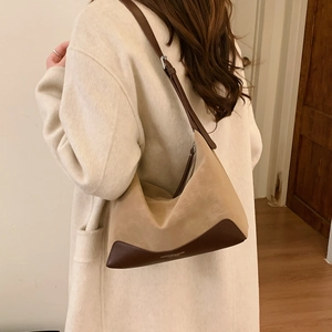 Detail of vintage contrast color hobo bag worn with a light beige wool coat
