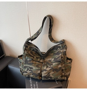 Detailed close-up of heavy-duty canvas camouflage shoulder bag with functional front pockets