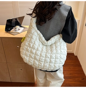 Détail du sac cabas matelassé blanc avec étiquette latérale jaune de mode urbaine