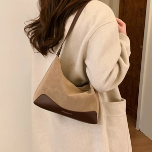 Detail of retro contrasting suede shoulder bag showing texture and size on model