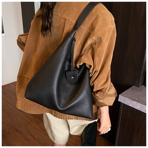 Detail of black pebbled leather tote bag showing large capacity and minimalist design