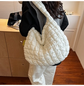 Détail du sac matelassé blanc montrant la texture rembourrée et l'étiquette de mode