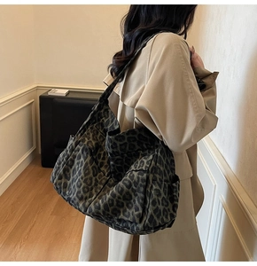 Detailed view of the leopard print canvas tote bag with side pockets and wide straps