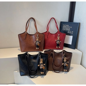 Detail view of large leather tote bags in various colors with cute rabbit charms